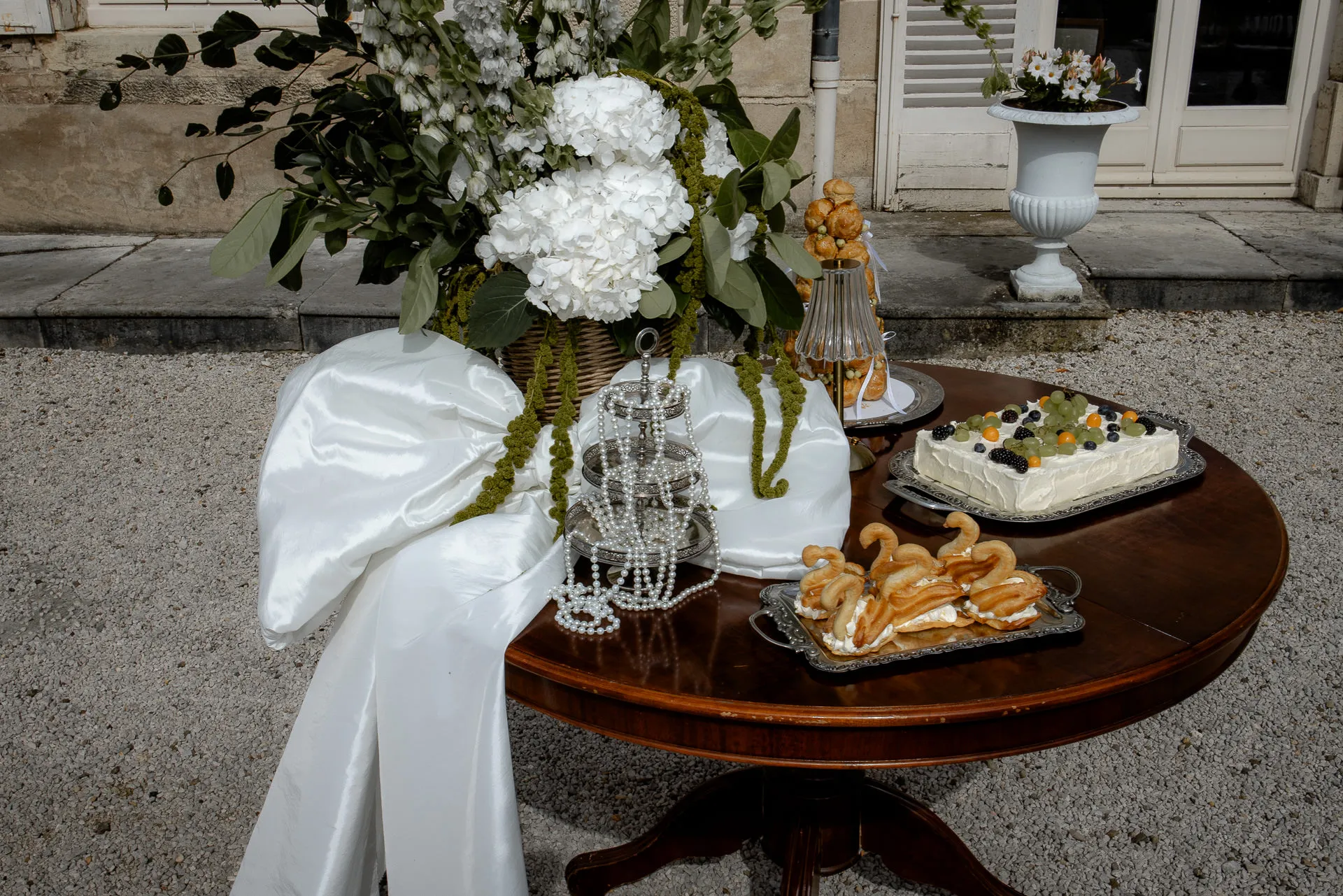 Eleganter Desserttisch mit Eclairs und Hochzeitstorte bei Luxus-Hochzeit am Chateau de Varennes